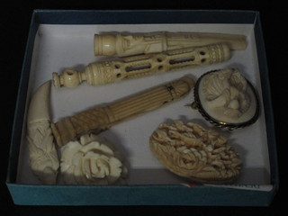 3 carved ivory brooches, a carved ivory cigarette holder, carved  ivory pendant, ivory needle case, f, and 1 other item