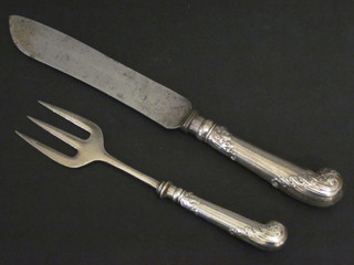 A Victorian steel bladed carving knife and fork with pistol grips
