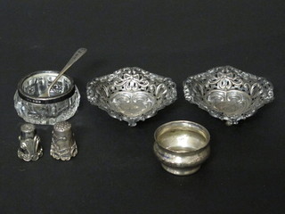 A pair of pierced white metal heart shaped dishes, raised on bun feet, 2 white metal thimbles, a silver salt, a glass salt  with silver mount and a condiment spoon