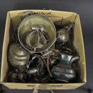 A cardboard box containing various silver plated teapots and  other items of plate