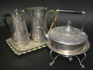 A circular silver plated tea kettle on stand purchased at Harrods, 2 silver plated hotwater jugs and 2 embossed silver plated dressing table trays