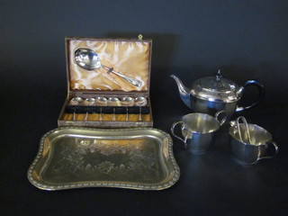 A circular silver plated teapot, twin handled sugar bowl and  cream jug and shaped embossed silver plated tray and a set of 6  silver plated fruit spoons