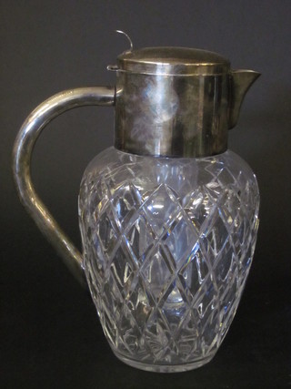 A cut glass insulated jug with silver plated mounts