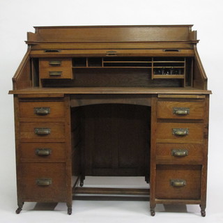 A Victorian honey oak kneehole pedestal roll top desk with three-quarter gallery, having a well fitted interior above 8 short  drawers 47"