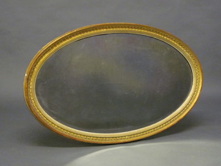An oval bevelled plate wall mirror contained in a gilt frame 36"