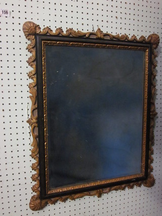 A rectangular bevelled plate mirror contained in a decorative  black and gilt frame 22" x 19"