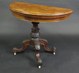 A Victorian figure walnut demi-lune card table, raised on carved pillar and tripod base 34"