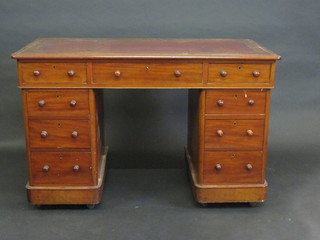 A Victorian walnut kneehole pedestal desk with inset tooled writing surface, above 1 long and 8 short drawers, 49"