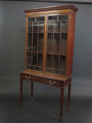 A 19th Century mahogany side cabinet with moulded cornice, the interior fitted adjustable shelves enclosed by astragal glazed  panelled doors, the base fitted 1 long drawer raised on square  tapering supports ending in spade feet 37"