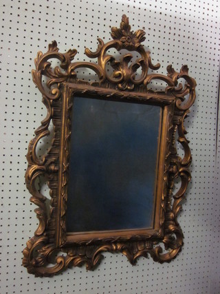 A rectangular bevelled plate wall mirror contained in a pierced decorative gilt frame 30" x 20"