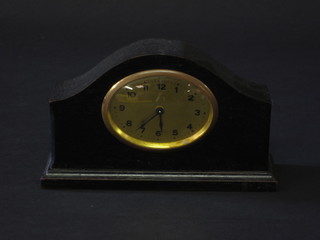 A bedroom timepiece with oval gilt dial and Arabic numerals contained in an ebonised case 6"
