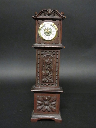 A miniature longcase clock contained in a carved wooden case  15"