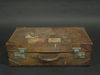 A leather suitcase with chrome fittings and various luggage  labels 24" x 14"