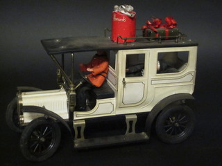 A pressed metal model of a vintage car containing various  Harrods boxes, 10"