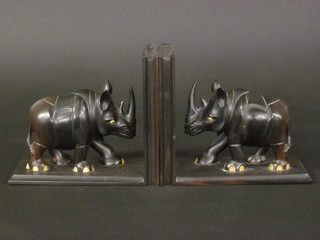 A pair of ebony bookends in the form of charging Rhino