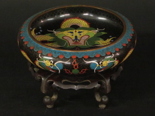 A circular black ground cloisonne enamelled bowl, raised on a hardwood stand 10"