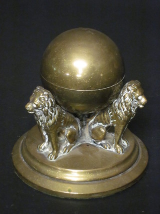 A globular brass inkwell supported by 3 lions complete with  porcelain liner 4"