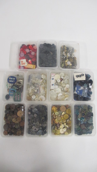 A collection of buttons contained in 11 various shallow boxes