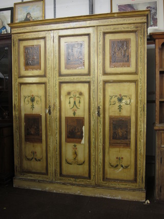 A white painted pine double wardrobe with moulded cornice, enclosed by panelled doors with painted and print decoration,  raised on a platform base 75"