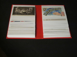 A red card album containing various WWI, later and coloured postcards