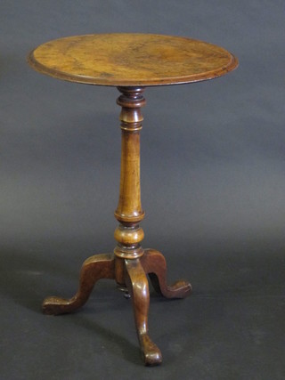 A circular Victorian figured walnut wine table, raised on a turned  column and tripod base, 19"