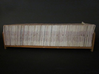 An oak book trough containing various editions of War Picture Library