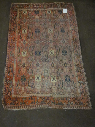 A pink ground Persian rug with stylised octagons to the central field within multi-row borders 85" x 53"