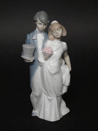 A Lladro figure group of a standing bride and groom, base  incised 1664, 8"