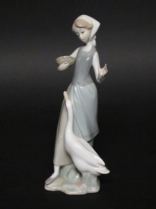 A Lladro figure of a standing girl with geese 9"