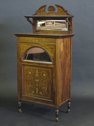 A Victorian rosewood music cabinet with raised mirrored back, the base fitted a cupboard enclosed by an inlaid panelled door  with, raised on turned supports