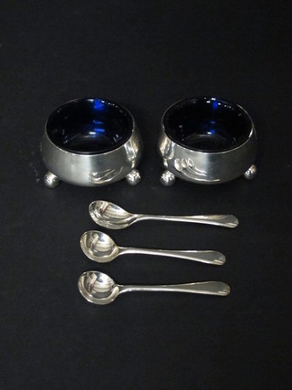 A pair of circular silver salts raised on bun feet with blue glass liners, together with 3 non matching silver salt spoons, Sheffield  1895, by Mappin & Webb, 2 ozs