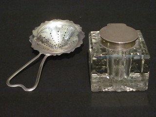 A cut glass inkwell with silver collar, London 1921, glass  cracked together with a silver tea strainer, Birmingham 1920
