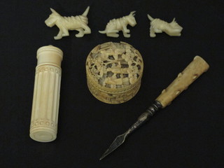 A cylindrical ivory needlecase, an ivory handled nut pick, a cylindrical carved ivory jar and cover 1 1/2" and 3 plastic Scottie  dogs