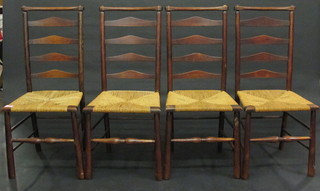 A set of 4 elm ladder back dining chairs with woven rush seats  raised on turned supports