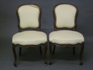 A set of 4 Victorian mahogany show frame dining chairs with upholstered seats and backs, raised on French cabriole supports