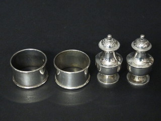 A pair of Victorian miniature silver baluster shaped pepperettes,  Birmingham 1892 and a pair of plain silver napkin rings, 2 1/2  ozs