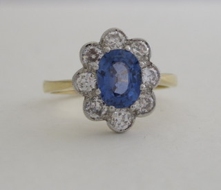 A lady's 18ct yellow gold dress ring set an oval cut sapphire surrounded by diamonds, approx 0.85/1.55ct