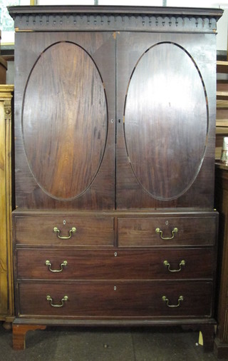 A 19th Century mahogany linen press with moulded cornice, the  interior fitted trays above 2 short and 2 long drawers, raised on  bracket feet with brass swan neck drop handles 51"