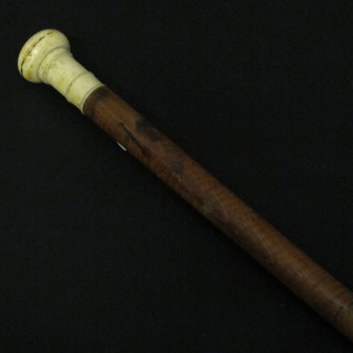 A turned cane with ivory handle