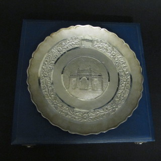 A circular embossed Eastern white metal dish raised on 3 cast  feet 10"