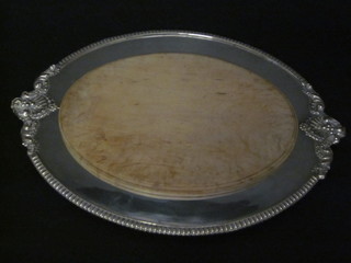 An oval bread board contained in a silver plated mount
