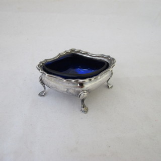 A silver shaped salt with blue glass liner