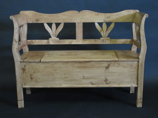 A stripped and polished Continental pine settle with pierced back  and hinged lid 48"