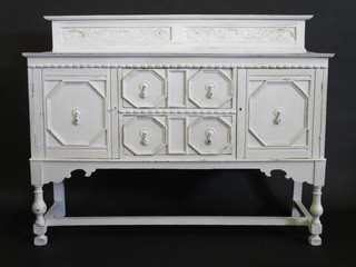 A 1930's white painted Jacobean style sideboard with raised back  above 2 long drawers flanked by a pair of cupboards, raised on  turned and block supports 60"