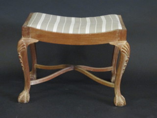A Georgian style limed oak saddle shaped stool with upholstered  drop in seat, raised on cabriole ball and claw supports with X  framed stretcher 23"