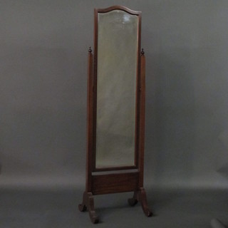 An arched plate cheval mirror contained in a mahogany swing  frame