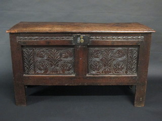 An 18th Century carved elm coffer with hinged lid and carved  panels to the front 45 1/2"