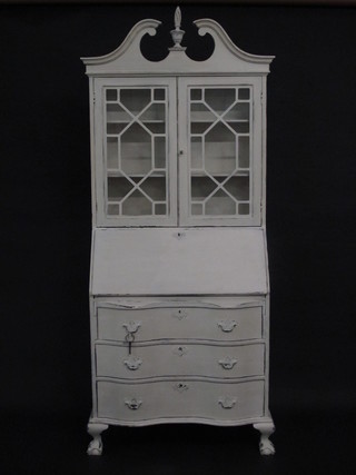 A Georgian style white painted bureau bookcase the upper section  with broken pediment, the shelved interior enclosed by astragal  glazed panelled doors, the fall front revealing a well fitted  interior above 3 long drawers of serpentine outline raised on  cabriole supports 34"