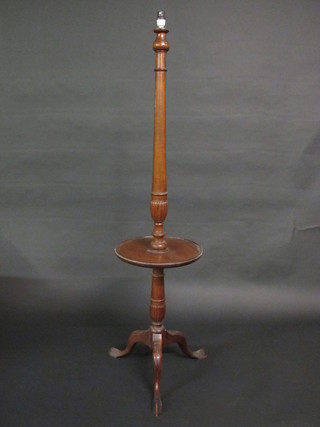 A circular turned walnut standard lamp the base incorporating a  wine table, raised on pillar and tripod supports