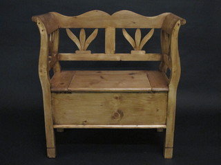 A Continental stripped and polished pine settle with pierced back  and hinged lid 34"